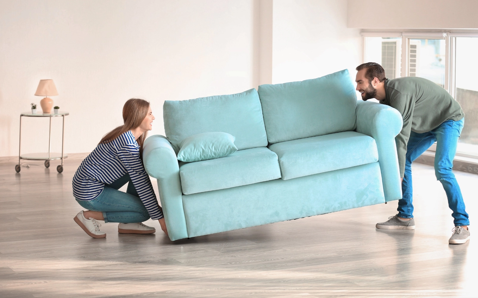 Before-CarpetInstall Couple moving sofa | Legend Flooring